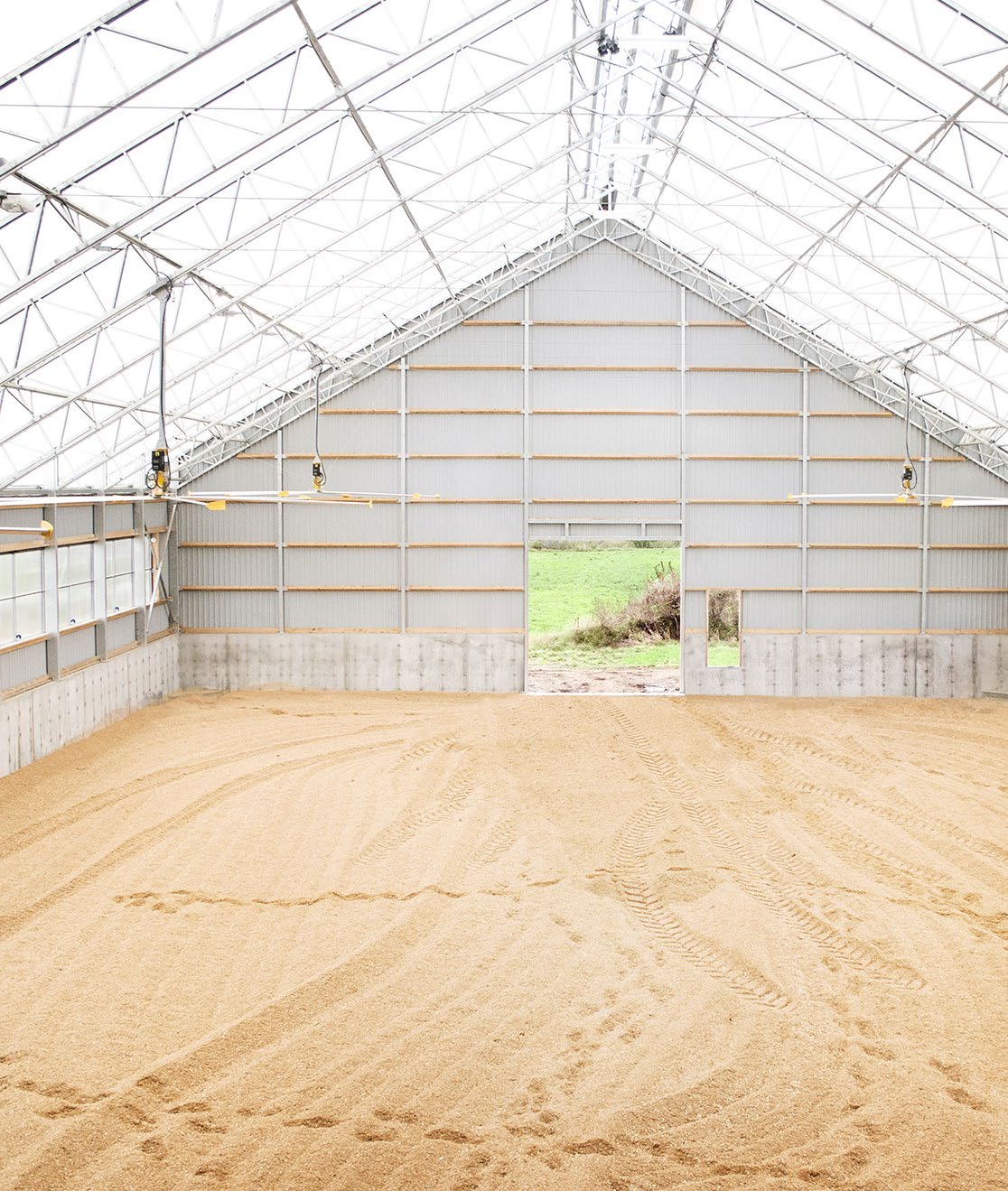 Interior of an A-frame fabric building with steep pitched roof and natural light