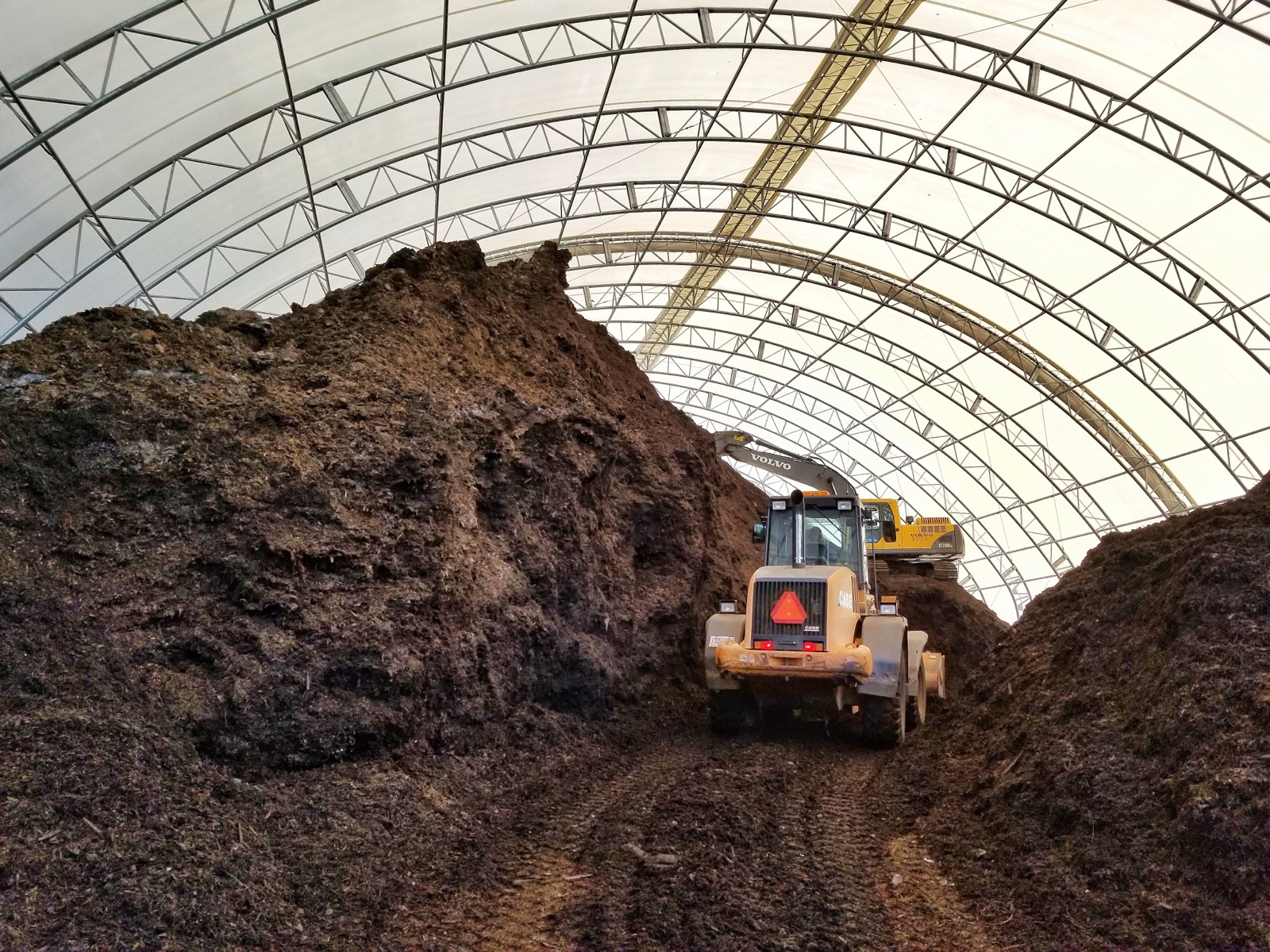 Loader working inside a composting facility fabric building