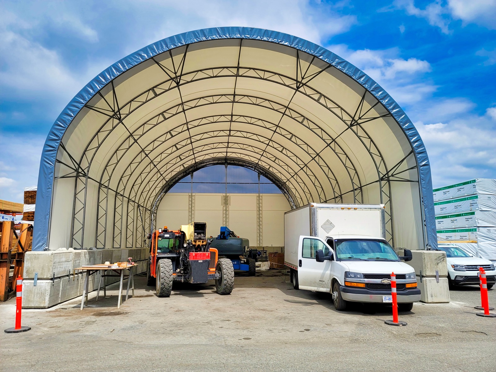 Municipal operations equipment sheltered in an open-end fabric building