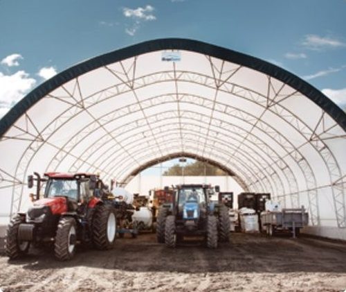 Fabric building open end wall with tractors inside