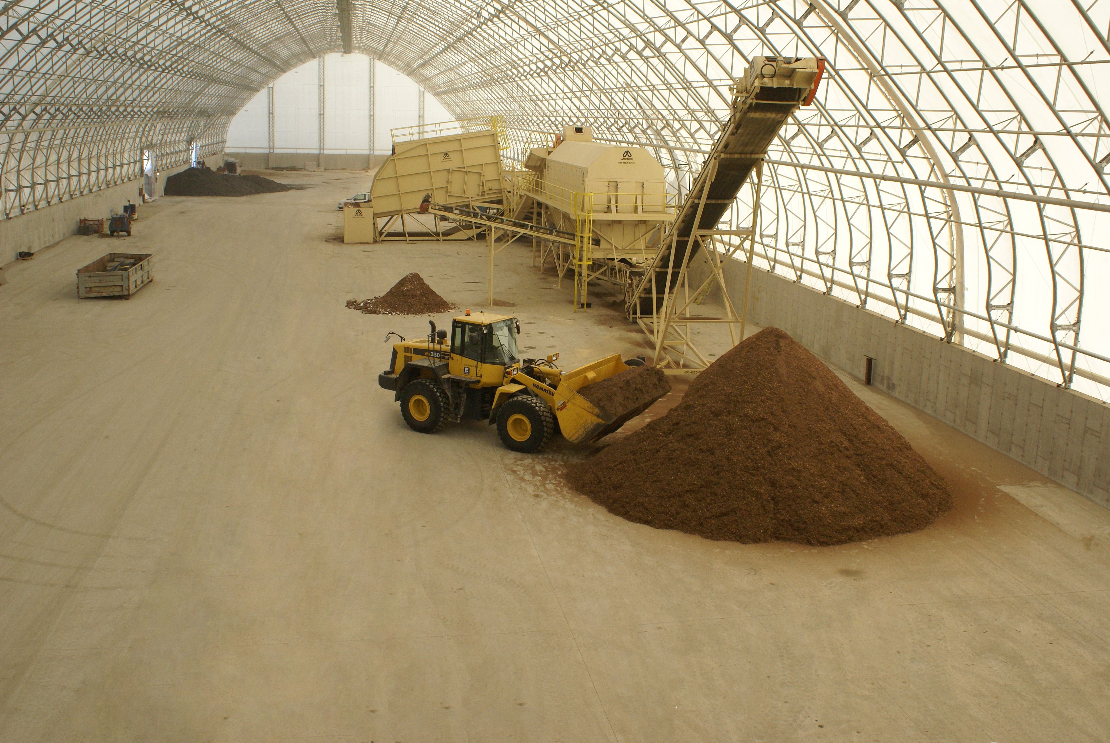 Semi-truck and palletized cargo inside a clear-span fabric building warehouse